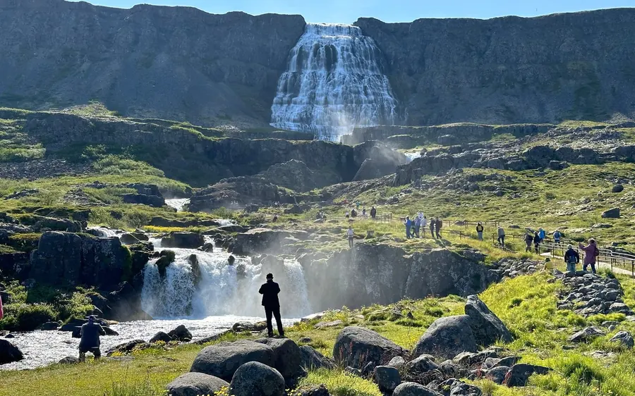 A visitor standing on the rocks below one of the lower falls at Dynjandi