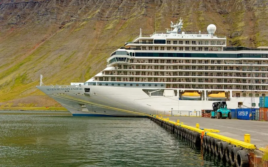 A cruise ship at the pier below the Westfjords mountains