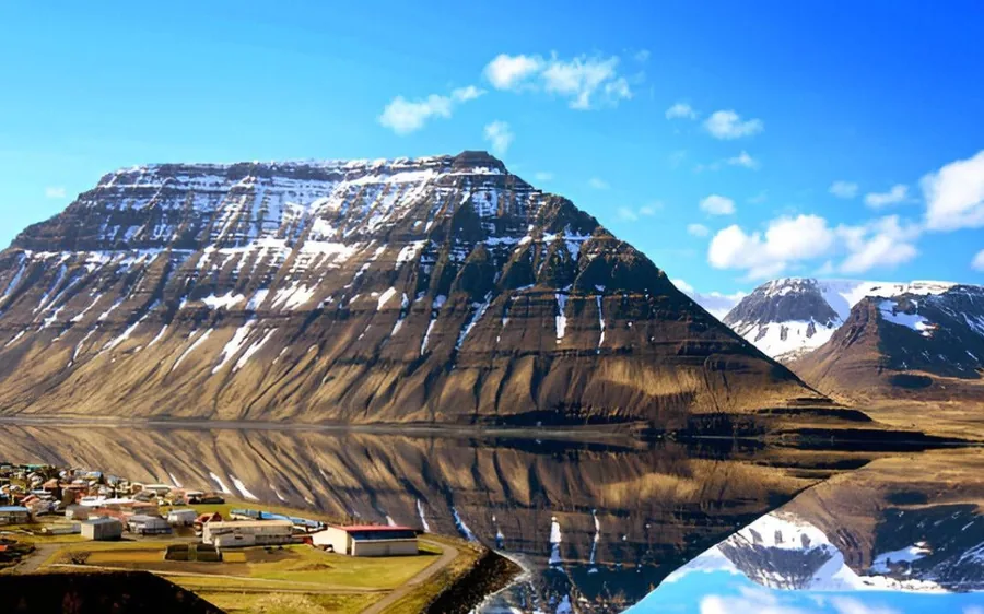 The flat-topped mountain above the town reflected in the fjord